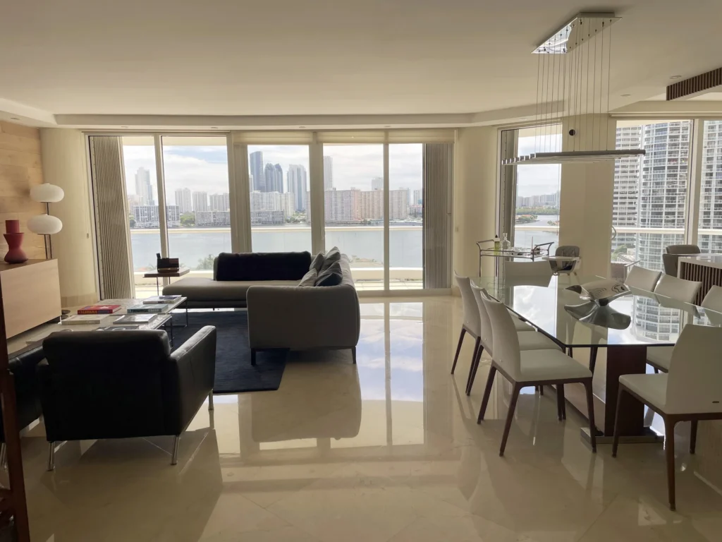 Sala y comedor con vista a la bahía / Living and dining area with bay view · Unidad 1401, 7000 Island Blvd, Aventura FL