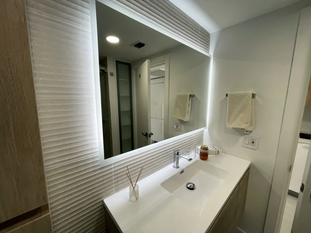 Detalle del vanity con espejo retroiluminado / Vanity detail with backlit mirror · Unidad 312, 7000 Island Blvd, Aventura FL