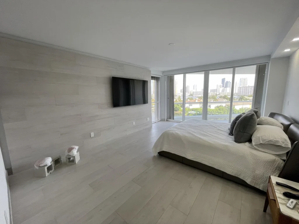Habitación principal con pared revestida / Primary bedroom with paneled wall · Unidad 701, 7000 Island Blvd, Aventura FL